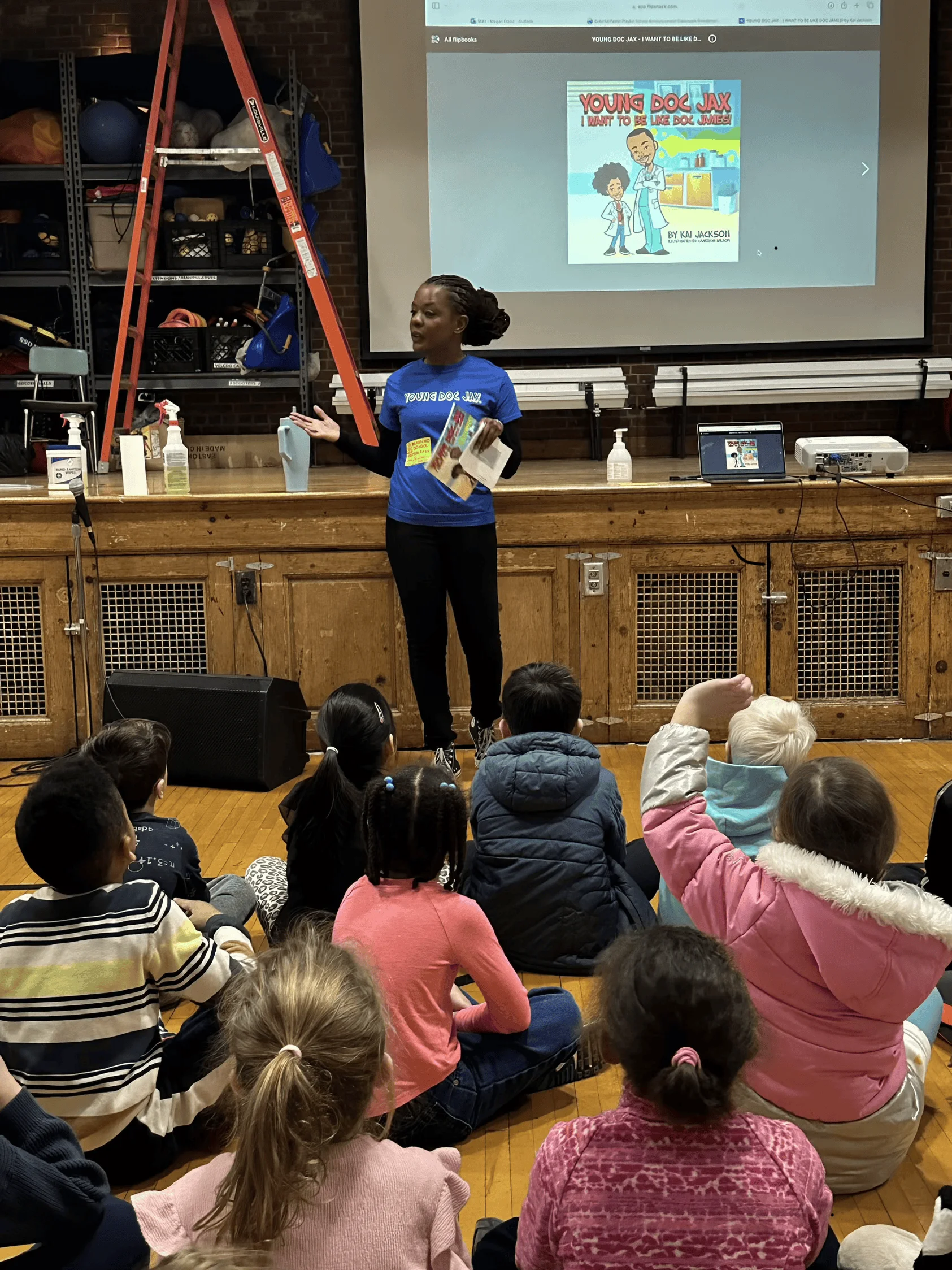 Woman standing in front of a group of children sitting on the floor